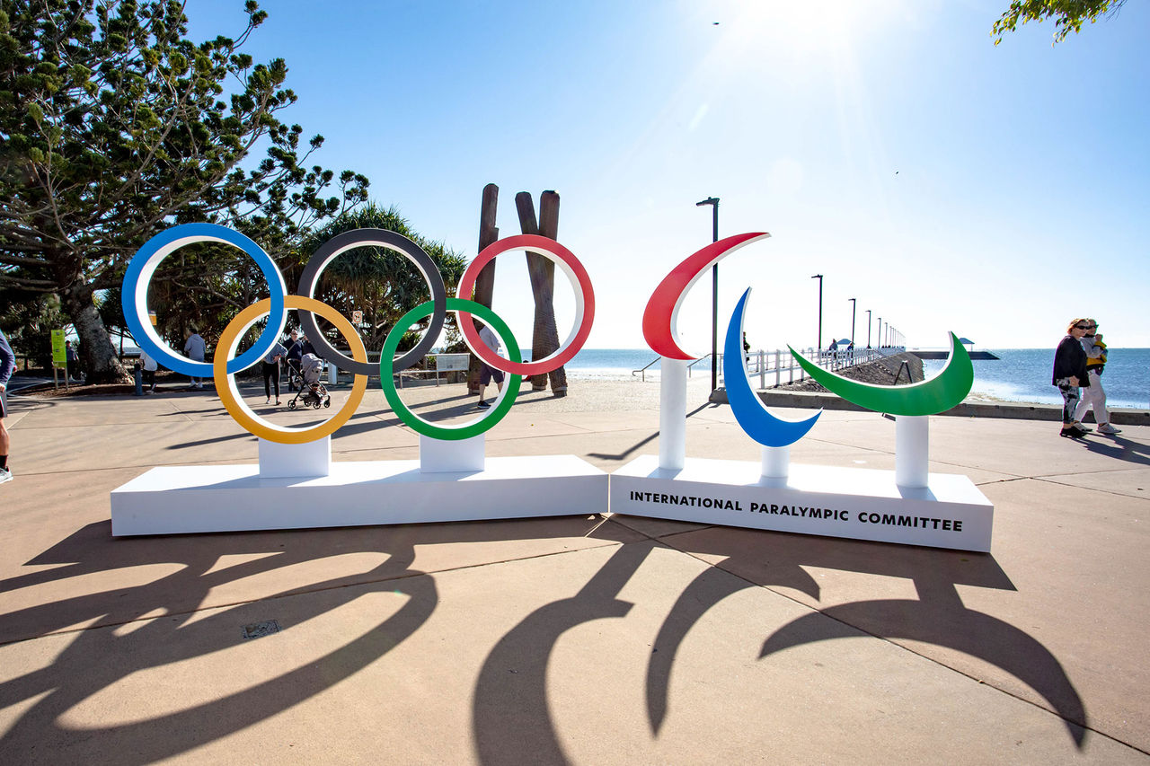 Olympic rings sculpture at the Wynnum Manly foreshore, with the bay behind